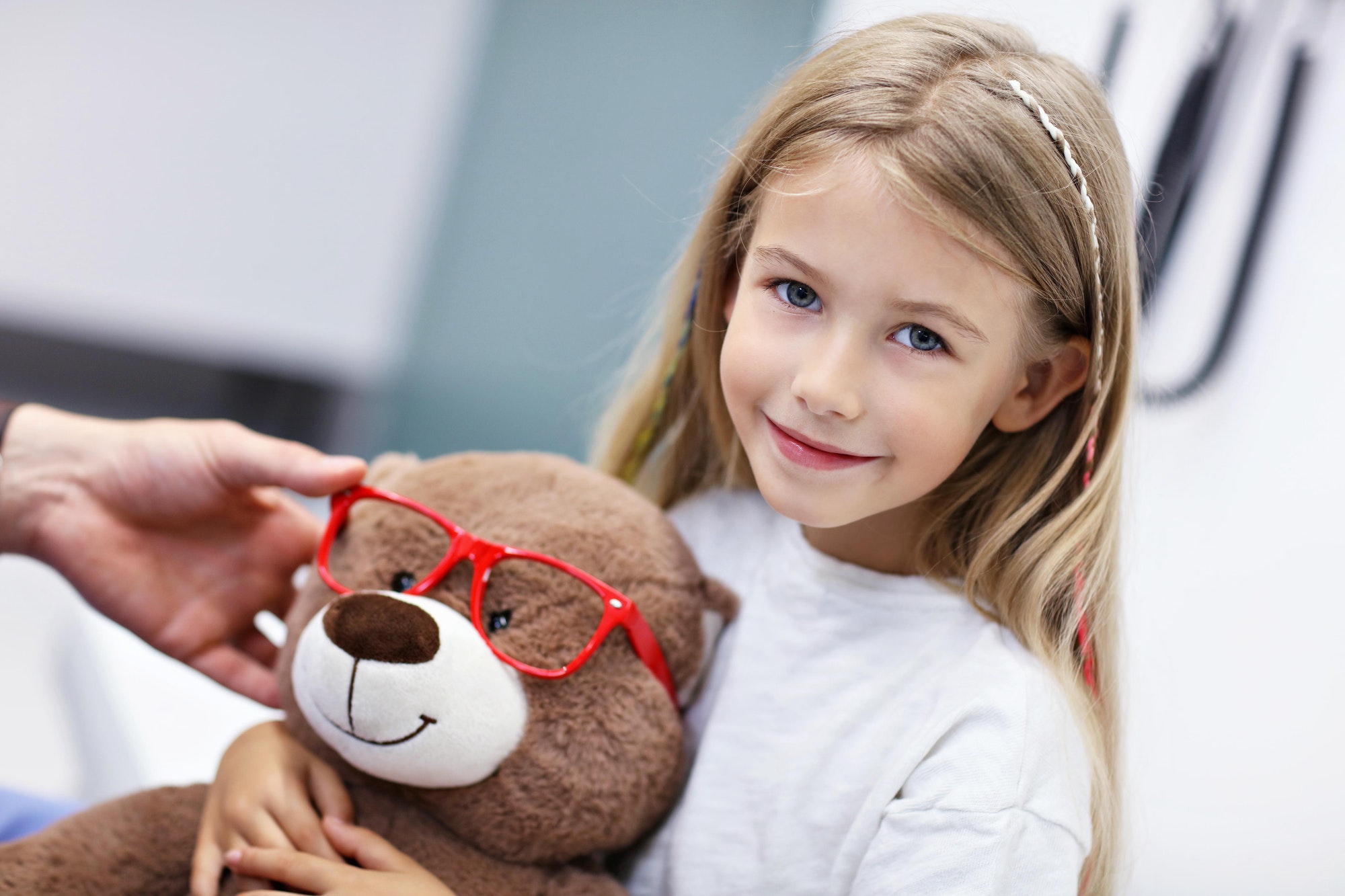 Child male optometrist examines eyesight of little girl